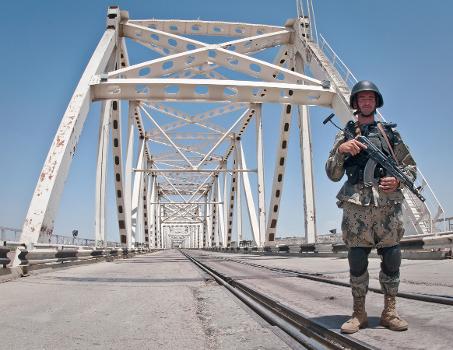 Afghanistan-Uzbekistan Friendship Bridge : BALKH PROVINCE, Afghanistan (May 27, 2010) —An Afghan Border Policeman stands watch on the Freedom Bridge crossing the Amu Darya River. On 15th February, 1989 the last Soviet troops to withdraw from Afghanistan crossed the bridge into the, then, Uzbek Soviet Socialist Republic. The bridge now carries rail and vehicular traffic and is the only border crossing between Afghanistan and Uzbekistan. (U.S. Navy photo by Petty Officer 1st Class Mark O’Donald)