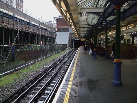 South Kensington tube station District and Circle line westbound/clockwise platform looking west/clockwise : Note remains of former District westbound platform on the left. The sloped structure visible ahead houses the escalators from the Piccadilly line to the ticket hall.