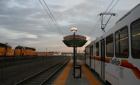 The 10th and Osage RTD light rail stop in Denver, Colorado. The Burnham Rail Shops/Yard is on the left.