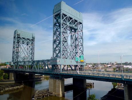 The William A. Stickel Memorial Bridge:A 1949 vertical-lift bridge carrying I-280 across the Passaic River between Newark and East Newark, New Jersey, viewed from a train on the parallel Newark Drawbridge (or Morristown Line Bridge).