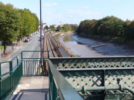 The Avon New Cut seen from Vauxhall Bridge : Cumberland Road is on the left and Coronation Road is unseen on the right. The cyclists are on the Chocolate Path (the blocks look like chocolate). The railway line is the Bristol Harbour Railway. Once the docks connection to Temple Meads station, it is now a heritage line.