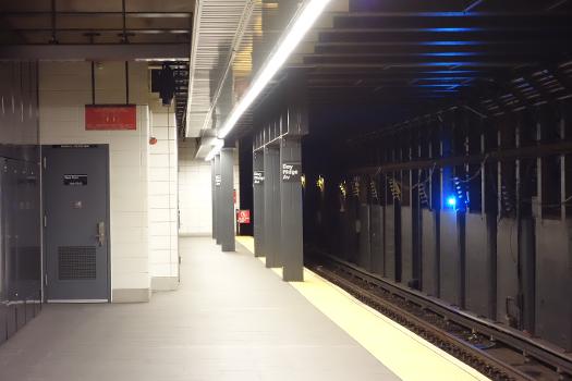 The far south end of the Manhattan-bound platform of the Bay Ridge Avenue BMT station, under 4th Avenue and Bay Ridge Avenue in Bay Ridge, Brooklyn : This platform is much wider than the Brooklyn-bound platform, as it was intended to be the Manhattan-bound express trackway had the station been expanded to four tracks to facilitate a Staten Island river tunnel. Note the six lonely columns at this end of the station; this was likely where the platform was extended to make it 600+ feet long.
