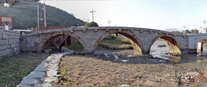 The Beolgyo Stone Arch Bridge spans the Beolgyo River in Beolgyo, South Jeolla Province, South Korea : Beolgyo Arch Bridge was originally built in 1729 and then called the Rainbow Bridge. Restored in 1737 and 1844 the bridge takes ist present form from work completed in 1984.
Beolgyo Arch Bridge is Treasure # 304.