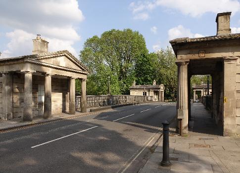 Cleveland Bridge in Bath, built in 1826. : It needed a toll house. In order to maintain the absolute symmetry of his neoclassical design, the architect, Henry Goodridge, designed not just one but four buildings, in the form of miniature temples. Number 1 was used to collect tolls, the rest let as shops or dwellings. The bridge was taken over by the Council in the mid-1920s and the tolls were abolished in 1927. Three of the "temples" are still houses, the fourth is a ceramics studio.