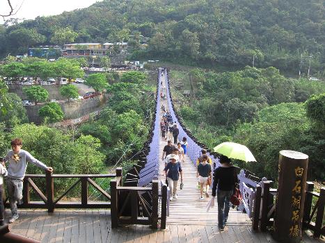 Crowds of tourists walk over Baishihu Suspension Bridge