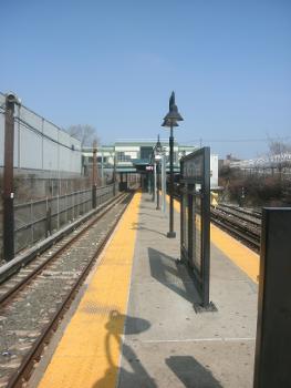 East 105th Street Subway Station (Canarsie Line) : East 105th Street station facing northbound towards the station house. One of the station's signs protrude near the foreground.