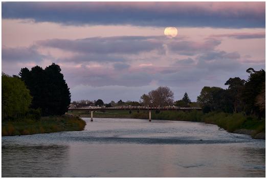 Full moon setting over the He Ara Kotahi bridge