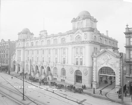 Newly-constructed General Post Office building:To the right is the entrance to the Queen Street Railway Station and the Waverley Hotel. To the left of the post office building is R & W Hellaby Ltd (butcher shop). Horse-drawn carriages are waiting outside the post office. Photograph taken by William A Price in 1912.
General Post Office and the Queen Street Railway Station, Auckland. Price, William Archer, 1866-1948 :Collection of post card negatives. Ref: 1/2-001654-G. Alexander Turnbull Library, Wellington, New Zealand.