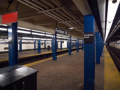 A view of Fordham Road station on the IND Concourse line from the southmost point of the northbound platform : This station is one of a few to, at the time of this photo, have had its platform edges painted entirely yellow to look more like modern Tenji tile-covered platform edges. The northbound platform also doesn't have COVID-19 distancing stickers.