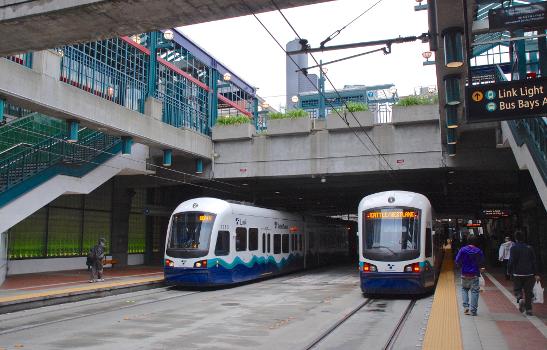 The Downtown Seattle Transit Tunnel's International District/Chinatown station with two Link light rail trains passing:This view is from the northbound platform, looking north. This DSTT station opened in 1990, for use exclusively by dual-mode buses (diesel/trolley) that operated as trolleybuses in the tunnel. It was modified in the late 2000s for use additionally by Sound Transit Link light rail, and Link service began in 2009.