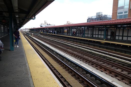 Looking east down the tracks from the west end of the Manhattan-bound platform of the 74th Street – Broadway IRT station:Above Broadway and 73rd Street in Jackson Heights / Elmhurst, Queens.