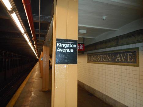 Kingston Avenue Subway Station : Small standard MTA Helvetica sign on the pillars along the Utica Avenue-bound platform of Kingston Avenue Subway Station on the IRT Eastern Parkway Line in the Crown Heights section of Brooklyn, New York City. A traditional IRT mosaic can also be seen on the wall on the right.
