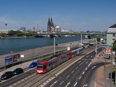 Cologne Stadtbahn train on the shores of the river Rhine in front of the Cologne skyline