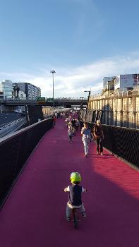 Canada Street Bridge:Looking north from the end of the Canada Street Bridge onto Lightpath proper, going underneath Karangahape Road overbridge. People walking and cycling along.