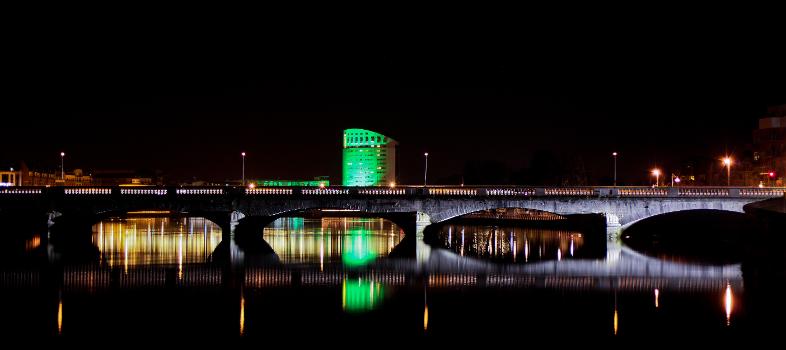 Limerick's Sarsfield Bridge in the foreground with The Clarion Hotel lit in green for St. Patrick Day