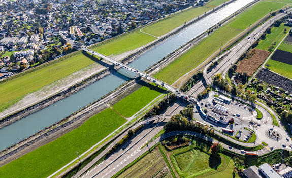 Luftbild der Rheinbrücke (Grenzbrücke) zwischen Au (CH) und Lustenau : Rechts sieht man das Zollgelände von Au mit dem Kreisverkehr und die Schweizer Autobahn (13). Die Brücke überspannt den Alpenrhein und das Rheinvorland. Links sieht man das Zollamt Lustenau.