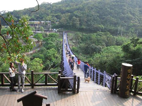 People walking along Baishihu Suspension Bridge