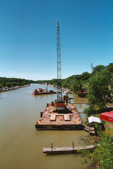 Construction crane at construction of the in July 2002, as seen from the no longer existing Stutson Street Bridge:The depicted crane was apparently manufactured by Crane Construction NW.