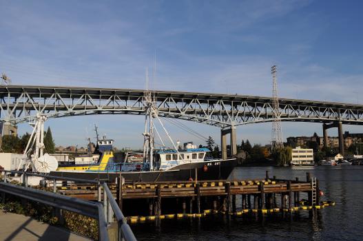 Ship Canal Bridge:Boats docked on north Lake Union (in foreground, the Ms. Amy), and Interstate 5 Ship Canal Bridge, Seattle, Washington, seen from the foot of Latona Ave NE.