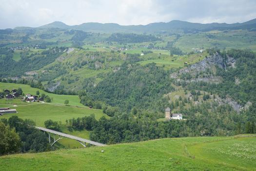 Valserrheinbrücke, Vals:Val Lumnezia (Kanton Graubünden) mit der Kirche Sogn Luregn und der Brücke nach Surcasti, darüber Vattiz und Vignogn (links), darüber der Piz Mundaun