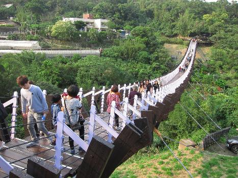 Tourists walking on the Baishihu Suspension Bridge