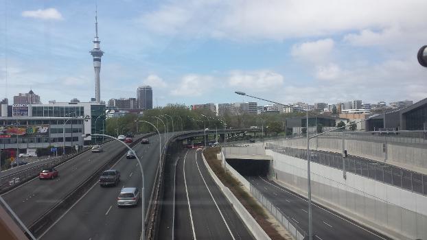 Victoria Park Tunnel:View of the State Highway 1 and the northern portal of the Victoria Park Tunnel with the Sky Tower and Auckland skyline in the background. The photo was taken from the Jacobs Ladder Footbridge