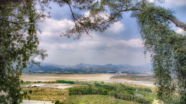 Laonong River passing through Xinwei Village, with the Yushan Range in the background. In the middle of the picture is Xinwei Bridge