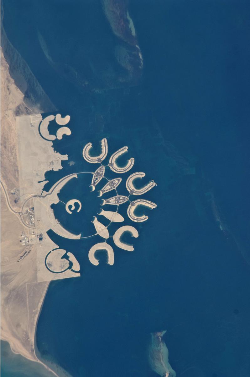 Media File No. 250054 This astronaut photograph shows that construction on the surface of the two southern atolls and petals has yet to begin. Artificial beaches have been created on the inner shorelines of the Crescent and petals, with smaller beaches on the inner ends of the atolls and Hotel Island. The angular outline of the golf course, where many more residences are planned, can be seen between The Crescent and the marina. What may be a second marina is being carved out at the south end of the complex (mirroring the one on the north), though no such marina appears in earlier published plans for Durrat Al Bahrain