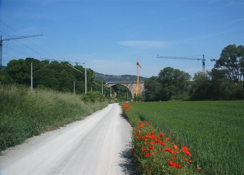 Mediendatei Nr. 29158 Autobahn A4 – Saaletalbrücke, Jena – Straße war früher nur ein Feldweg und ist jetzt auch nur ausgebaut bis zur Brücke. Eisenbahnlinie links ist die Strecke Leipzig-Nürnberg. Unter dem Brückenbogen rechts von dem gelben Kran fließt die Saale. Links unter dem blauen Laster auf der Brücke sieht man ein Stück der neuen Brücke