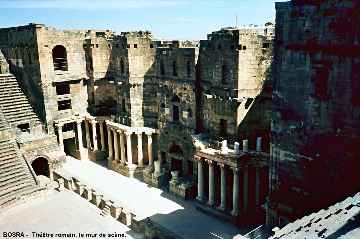 Fiche média no. 60378 BOSRA (BUSRĀ) – Ancienne capitale de la province romaine d'Arabie. Le théâtre construit sur un terrain plat au IIe siècle, transformé en forteresse au VIIIe par les Omeyyades, il fut renforcé au XIIIe par des remparts construits par les Ayyoubides. Sa cavéa pouvait accueillir 15 000 personnes