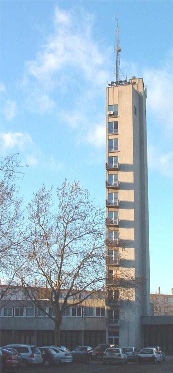 Fiche média no. 37687 Caserne des pompiers de Mulhouse (1972). Tour d'entrainement et de séchage des tuyaux. Hauteur du batiment: 43 m. Hauteur à la pointe de l'antenne: 56 m