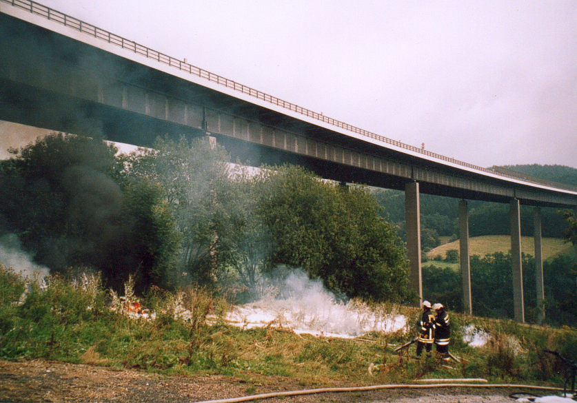Firemen are extinguishing the fire caused by a tanker truck accident on the Wiehltal Bridge on 26 August 2004 