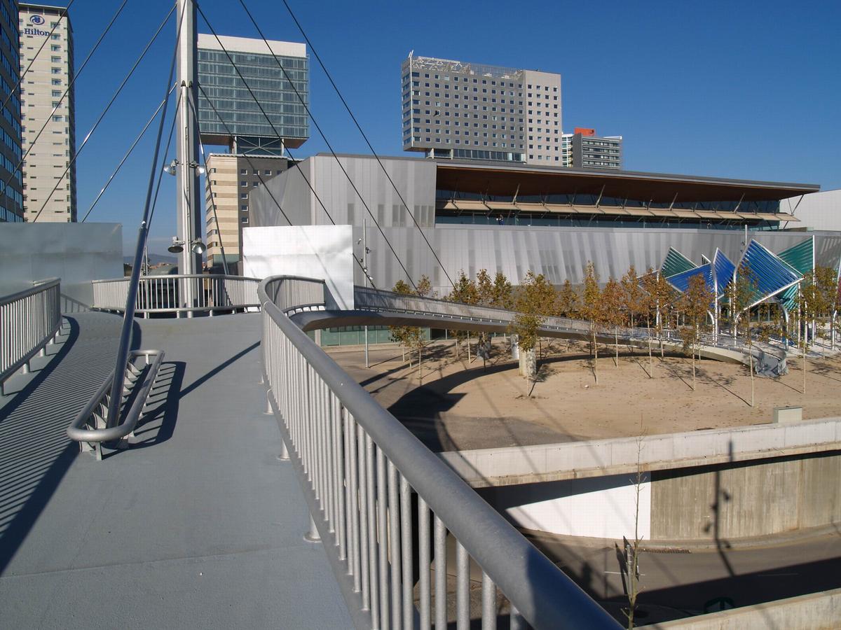 Fiche média no. 53248 Passerelle pour piétons à leur location actuelle, prés du cloître du Forum 2004. La première location étais à la place des Gloires Catalanes. Fut transféré après l'année 1991. Prix SERCOMETAL 1975 et prix Convention Européenne de Construction Métallique 1976. Fut le second ouvrage à haubans en Espagne, et le premier de Carlos Fernandez Casado