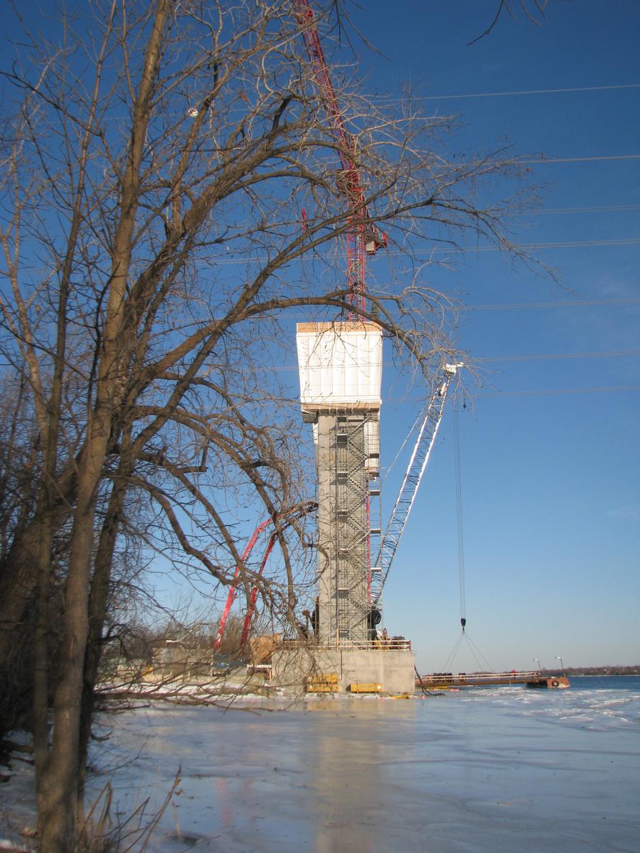 Fiche média no. 133026 Aperçu côté ouest du pilier nord et de ses mâts qui serviront à tendre les haubans. En regardant en aval vers le Nord-Est, Rive nord de la rivière Des-Prairies Laval Qc Ca