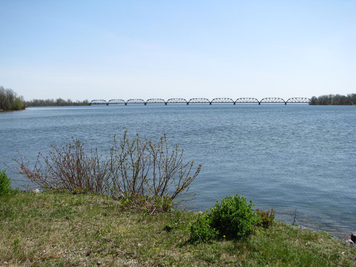Fiche média no. 185931 Pont ferroviaire des Coteaux; vu depuis la piste cyclable passant sur la digue d'Hydro Québec, il relie Une petite île dans le milieu du chenal à Coteau du Lac et Grosse-Île. (Salaberry de Valleyfield Qc Ca)