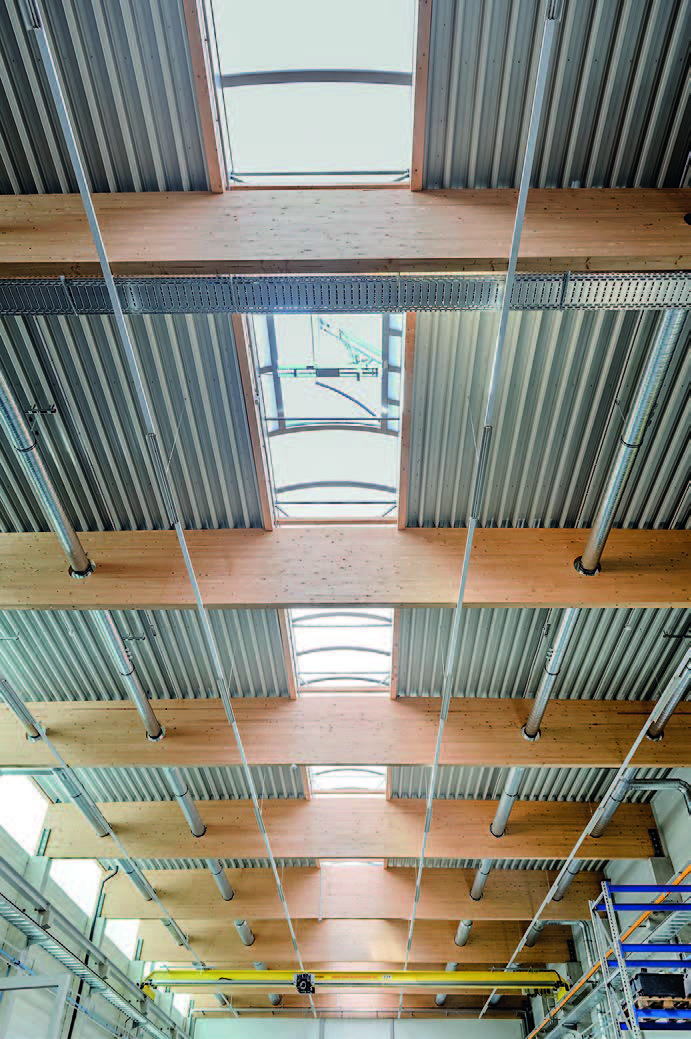 Blick auf die Unterseite des Dachs der modernen Holzbinderhalle mit dem Lichtbandsystem Topline ELS 1,1 von INDU LIGHT Blick auf die Unterseite des Dachs der modernen Holzbinderhalle mit dem Lichtbandsystem Topline ELS 1,1 von INDU LIGHT