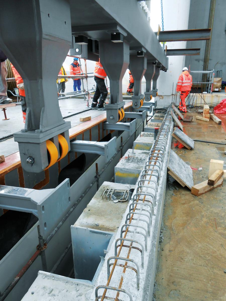 The view from below of an expansion joint construction with huge pins as a centering mechanism; the yellow castors are used as sliding units. 