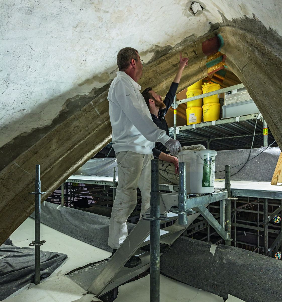 In 26 m Höhe wird die Gewölbedecke von Experten aufwendig per Hand saniert. 