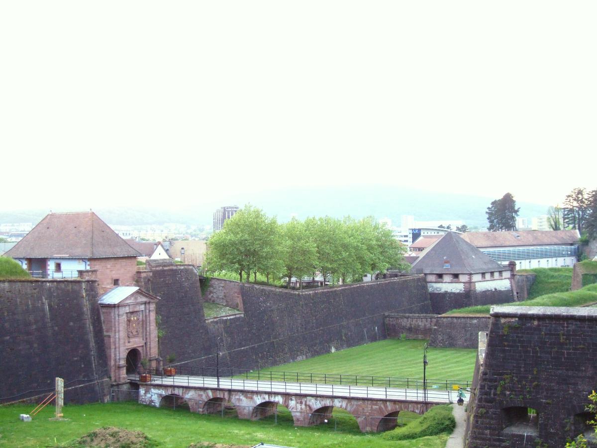 Fiche média no. 82278 Berlfort - Les remparts de la vieille ville - Porte de Brisach, rempart de la ville jusqu'à la tour n°27 avec sa contre-garde. La porte de Brisach est protégée par une demi-lune (n°26)