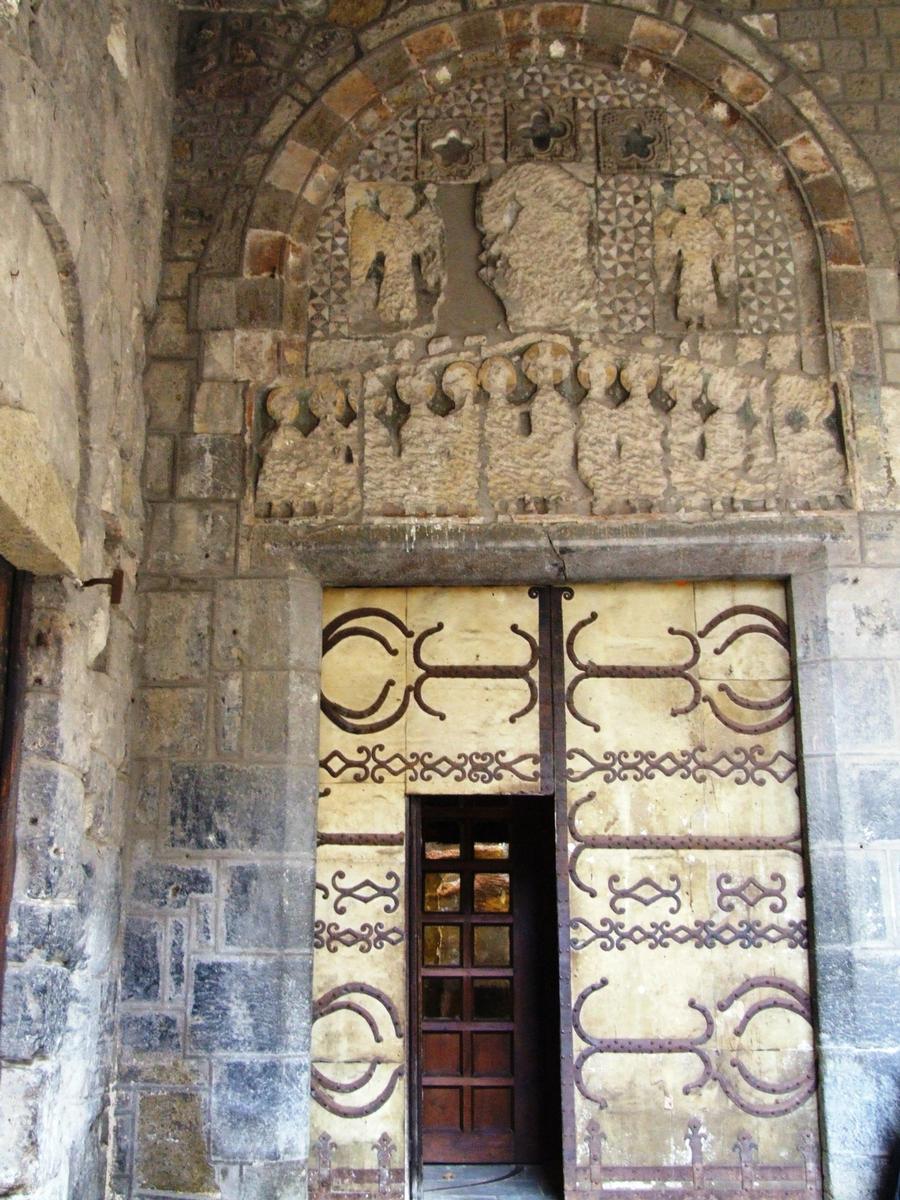 Fiche média no. 51404 Le Puy-en-Velay - Cathédrale Notre-Dame - Porche Saint-Jean - Porte donnant sur le bras nord du transept. Les vantaux ont conservé leurs pentures romanes. C'est la seule porte historiée de la cathédrale. Le linteau représente la Cène. Sur le tympan se trouvait le Christ entouré de deux anges