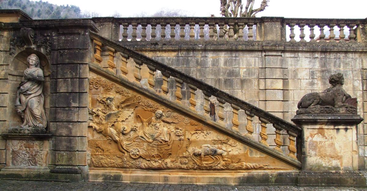 Fiche média no. 55883 Gorze - Ancien Palais abbatial - Mur d'échiffre de l'escalir de gauche avec une sculpture montrant Médée emportée dans les airs par deux dragons après le meutre de ses enfants