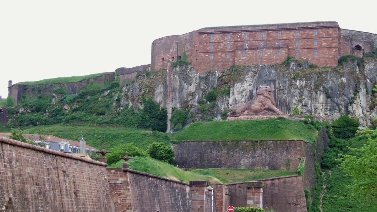 Fiche média no. 83709 Citadelle de Belfort - Le château avec, à son pied, le Lion de Belfort sculpté par Bartholdy pour commémoré la résistance du fort en 1870. En bas, à gauche, la courtine de la vieille ville