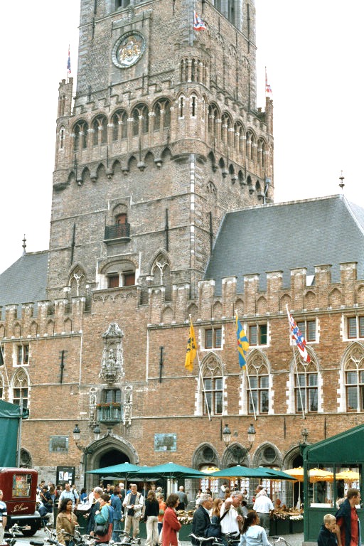 La façade des halles (1248-1300) de Bruges, imposant bâtiment aux 2 ailes symétriques de part et d'autre du beffroi 
