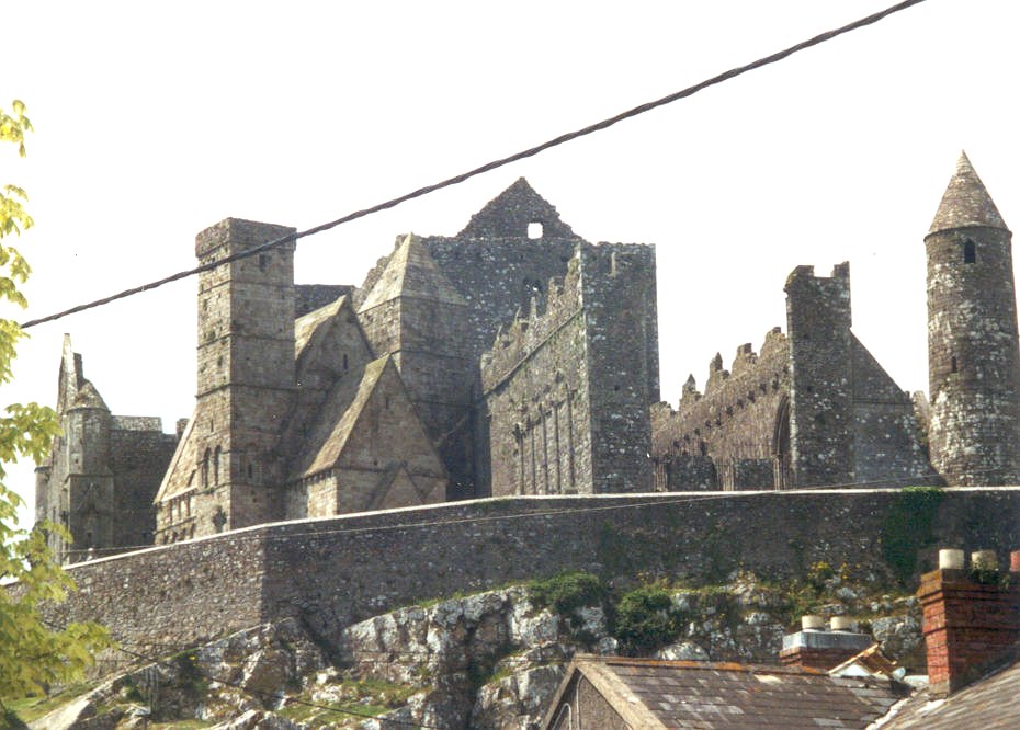 Fiche média no. 28431 Le rock of Cashel (comté de Tipperary) est composé de 4 bâtiments en pierre: à droite la tour ronde des 11e-12e siècles, au centre la cathédrale gothique (en ruines) du 13e siècle, à gauche, la Cormac's Chapel construite en 1127 et, à l'arrière plan le hall du Choeur du Vicaire, du 15e siècle