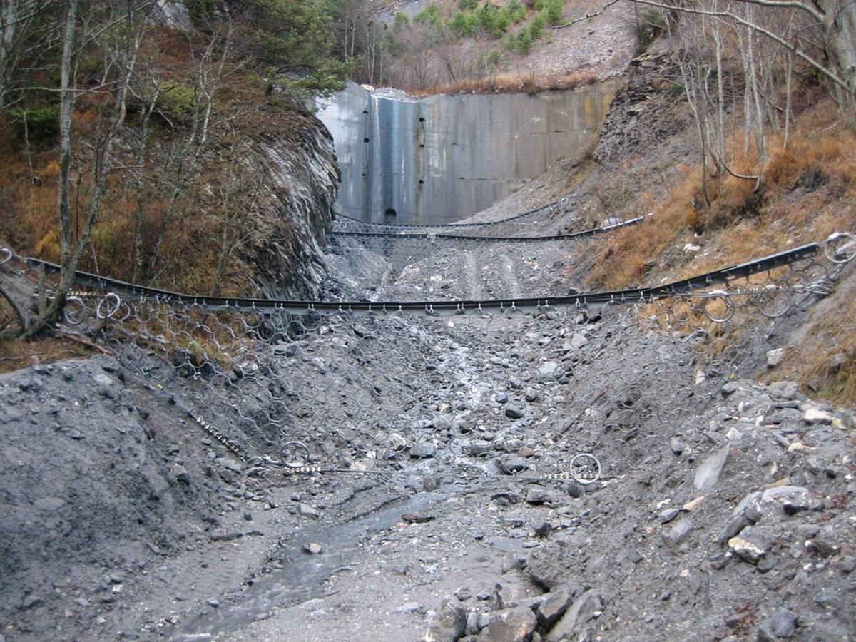 Die drei Murgang-Barrieren mit dem Staudamm im Hintergrund 