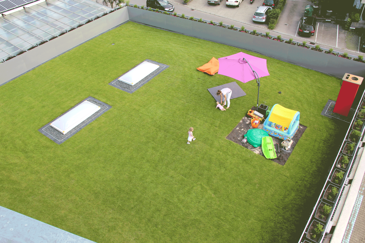 Eine schöne Rasenfläche zum Entspannen, Spielen und Genießen entstand auf dem Dach dieser Lagerhalle, an welche das neue Wohngebäude angrenzt 