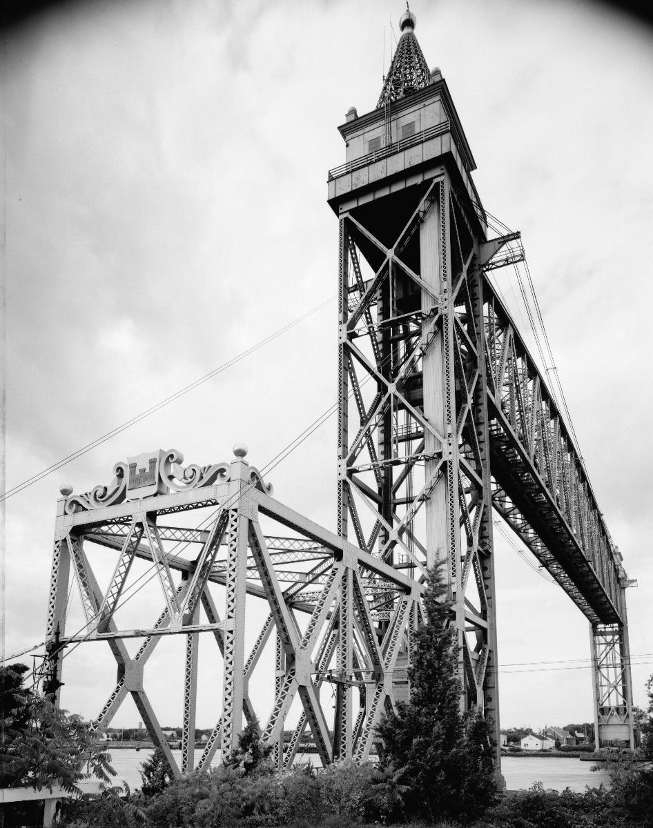 Media File No. 199216 VIEW OF SOUTHEAST TOWER AND PORTAL, CENTER SPAN IN MOTION, BEING LOWERED - Cape Cod Canal Lift Bridge, Spanning Cape Cod Canal, Buzzards Bay, Barnstable County, MA (HAER MASS,1-BUZBA,1–3)