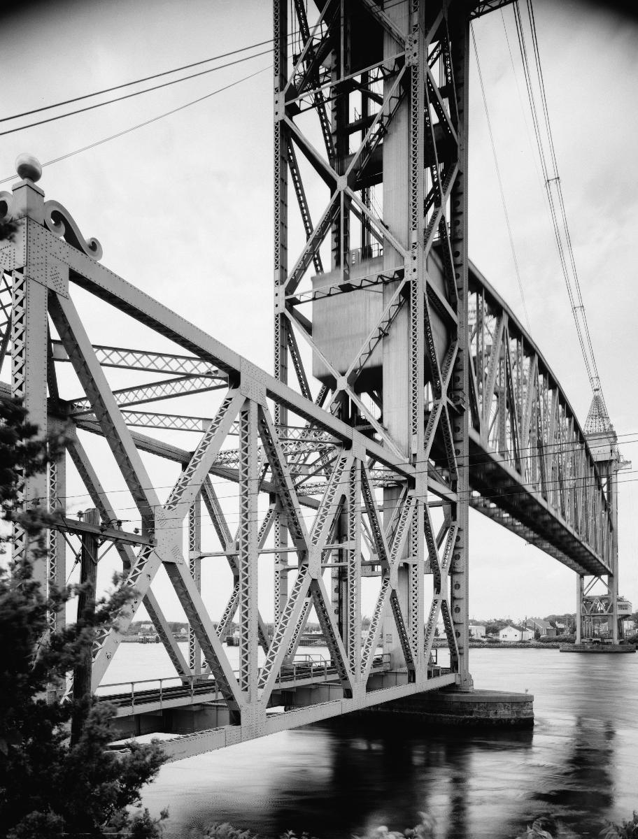 Media File No. 199217 DETAIL, VIEW OF SOUTHEAST TOWER AND PORTAL, CENTER SPAN IN MOTION, BEING LOWERED - Cape Cod Canal Lift Bridge, Spanning Cape Cod Canal, Buzzards Bay, Barnstable County, MA (HAER MASS,1-BUZBA,1–4)