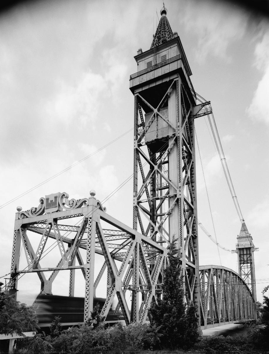 Media File No. 199218 SOUTHEAST TOWER AND PORTAL, WITH TRAIN PASSING - Cape Cod Canal Lift Bridge, Spanning Cape Cod Canal, Buzzards Bay, Barnstable County, MA (HAER MASS,1-BUZBA,1–5)