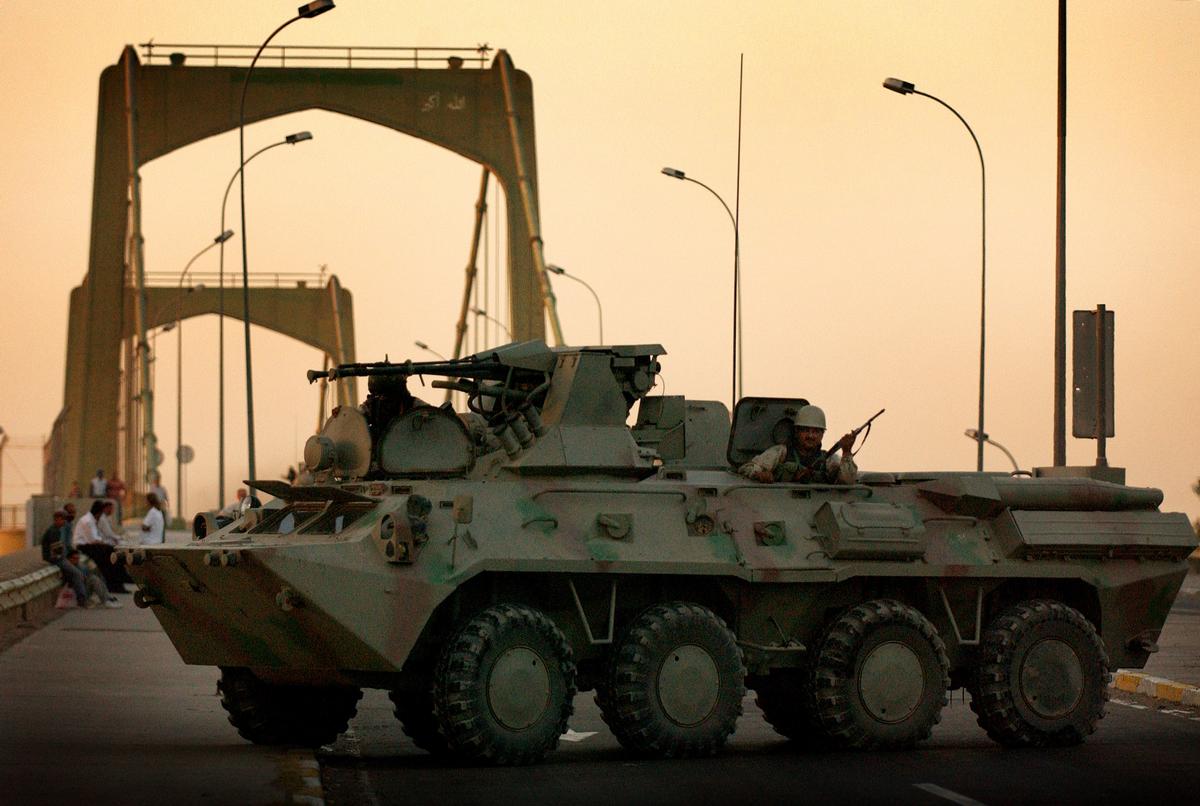 Media File No. 80254 In the early morning hours, Iraqi National Guard (ING) troops move a BTR-80A (8X8) Armored Personnel Carrier (APC) into position on the 14th of July bridge in Baghdad, Iraq (IRQ), to provide security for the Iraqi Democratic National Conference during Operation IRAQI FREEDOM